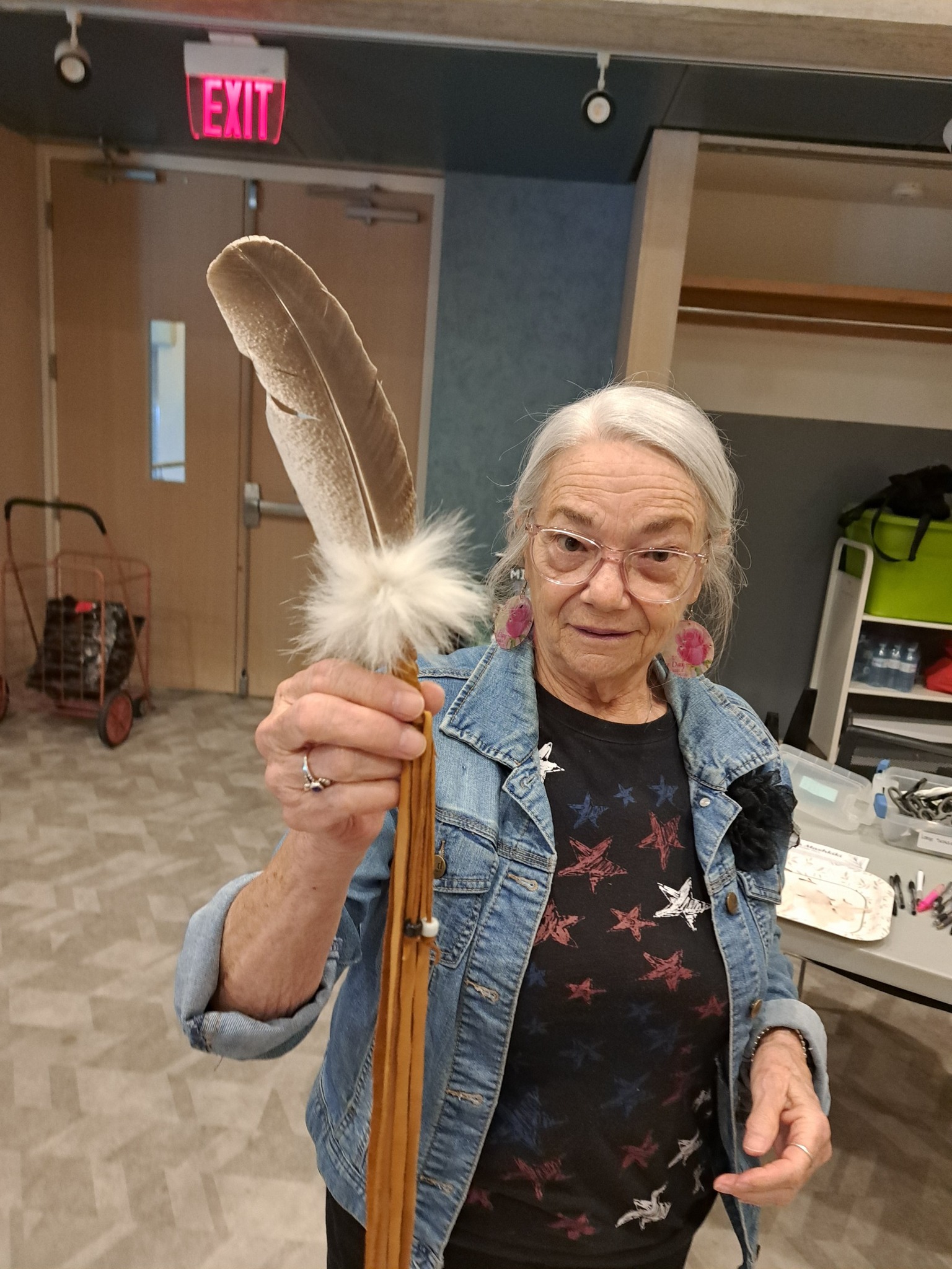 A woman holding up her finished smudge feather at an Indigenous workshop hosted by Miskwaadesi Studio in Richmond Hill, Ontario